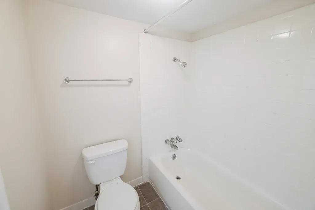 A bathroom with a toilet , bathtub and shower.