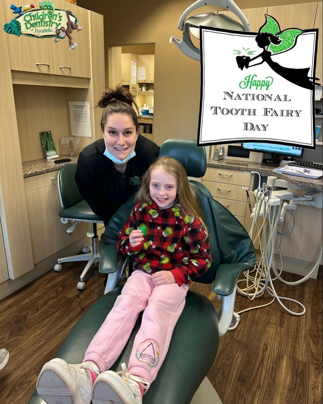 A dental assistant and child celebrate a missing tooth in a dentist's chair. 