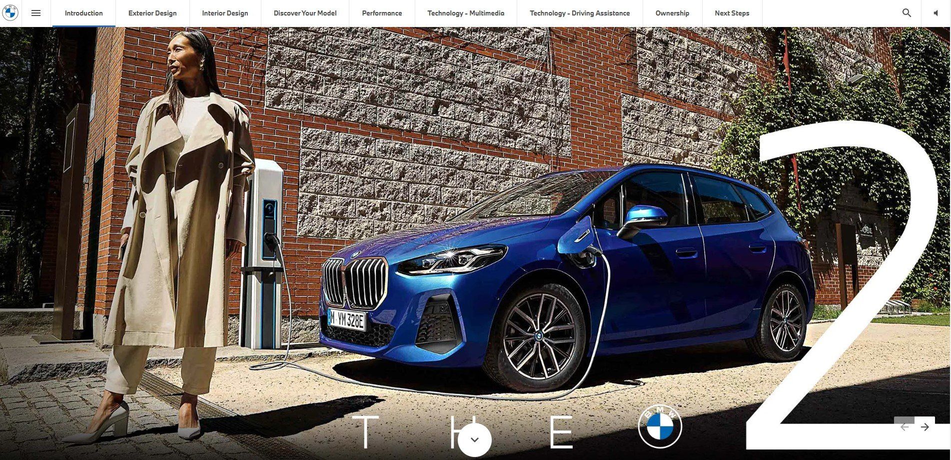 Blue BMW car charging, woman in a beige coat beside the car.