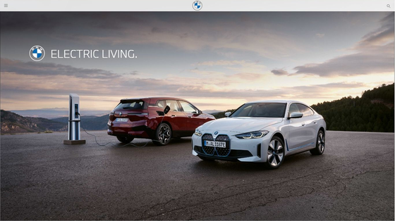 BMW electric vehicles at charging station with scenic background.