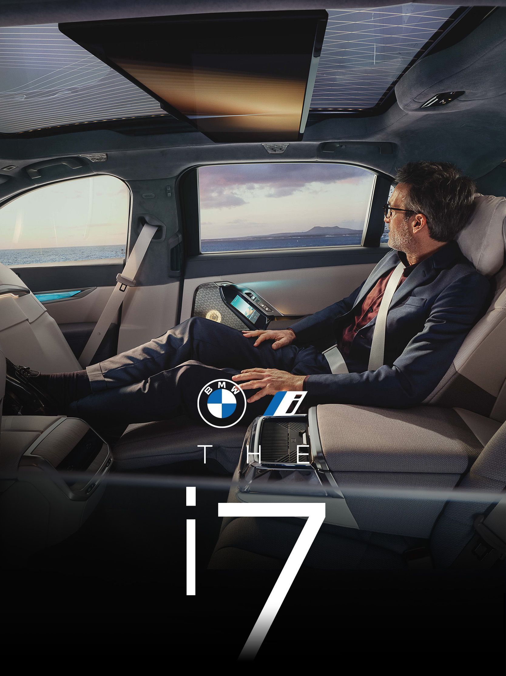 Man relaxing in luxury car interior, looking out a window.  BMW i7 logo is visible.
