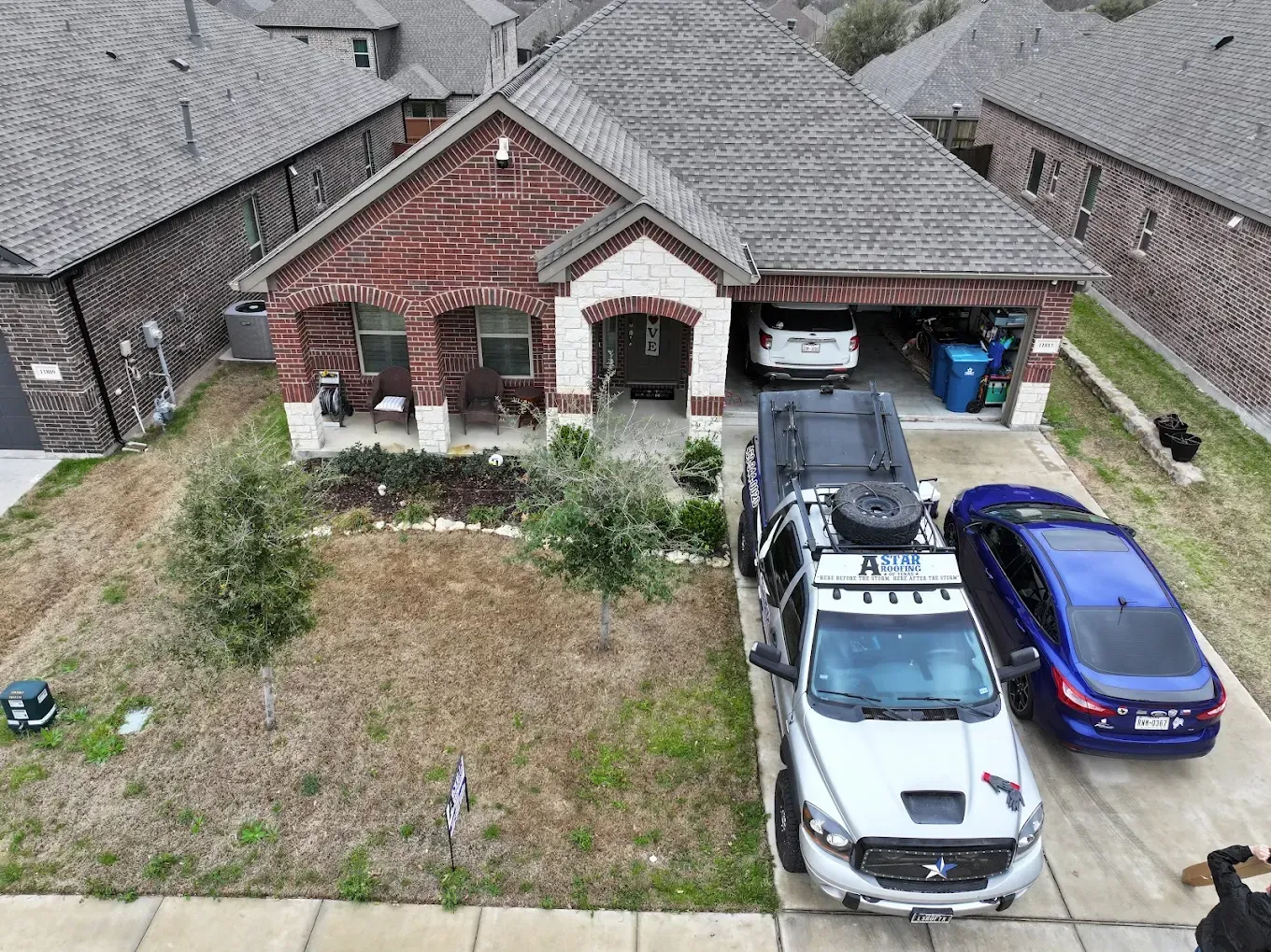 A truck is parked in a driveway next to a house.