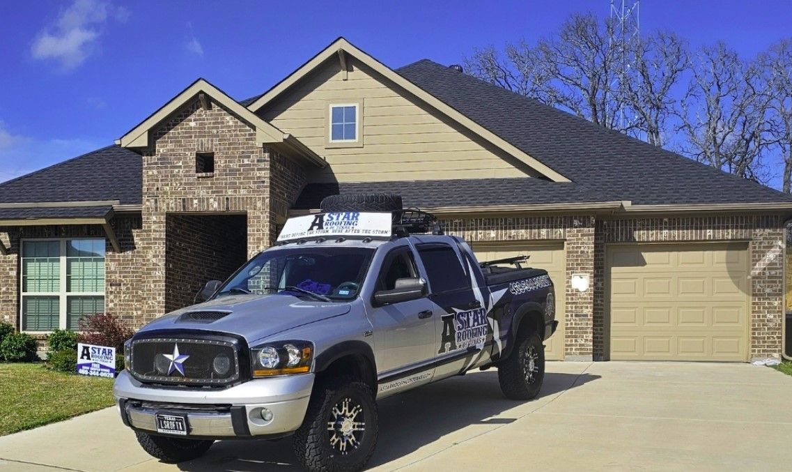 A silver truck is parked in front of a house.