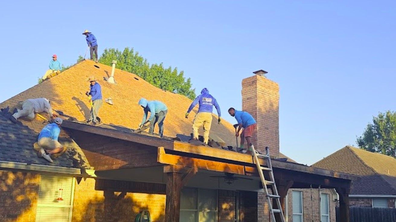 A group of people are working on the roof of a house.