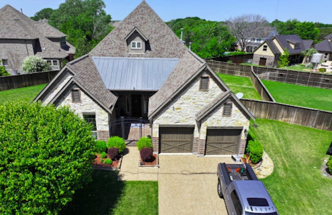 An aerial view of a large house with a truck parked in front of it.