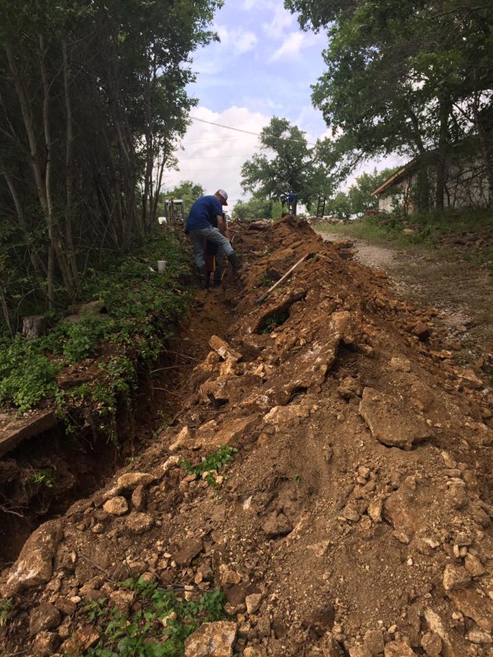 A man is standing on top of a pile of dirt.