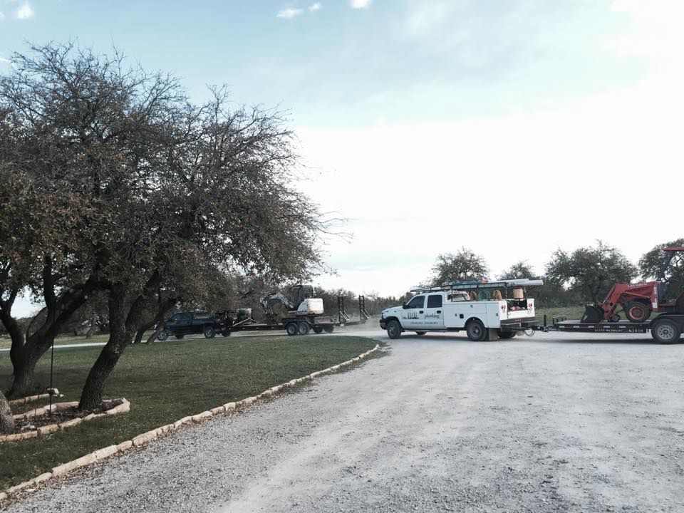 A tractor is being towed by a white truck