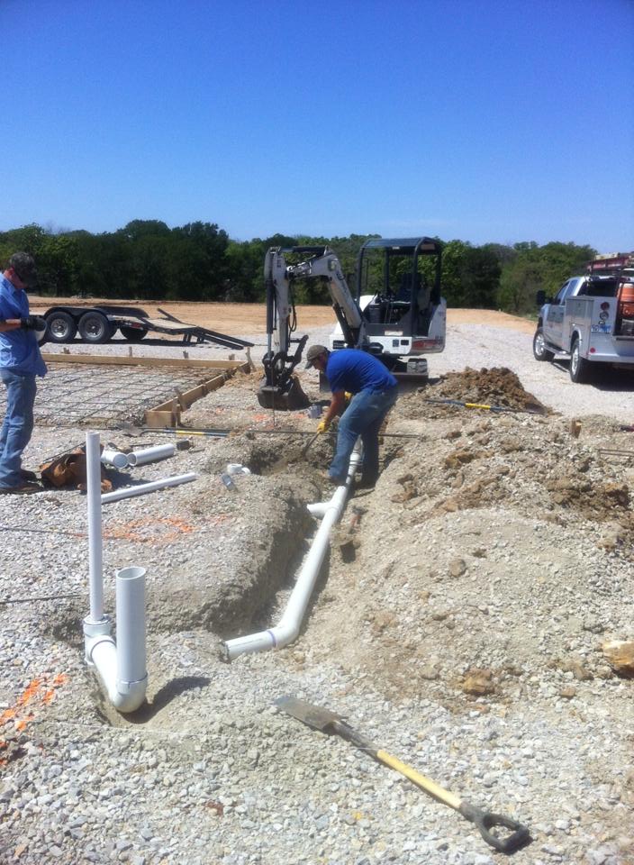 A man is digging a hole in the dirt with a shovel.