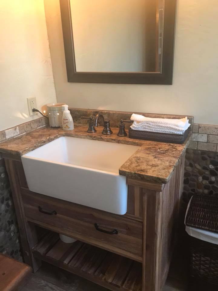 A bathroom sink with a wooden vanity and a mirror.