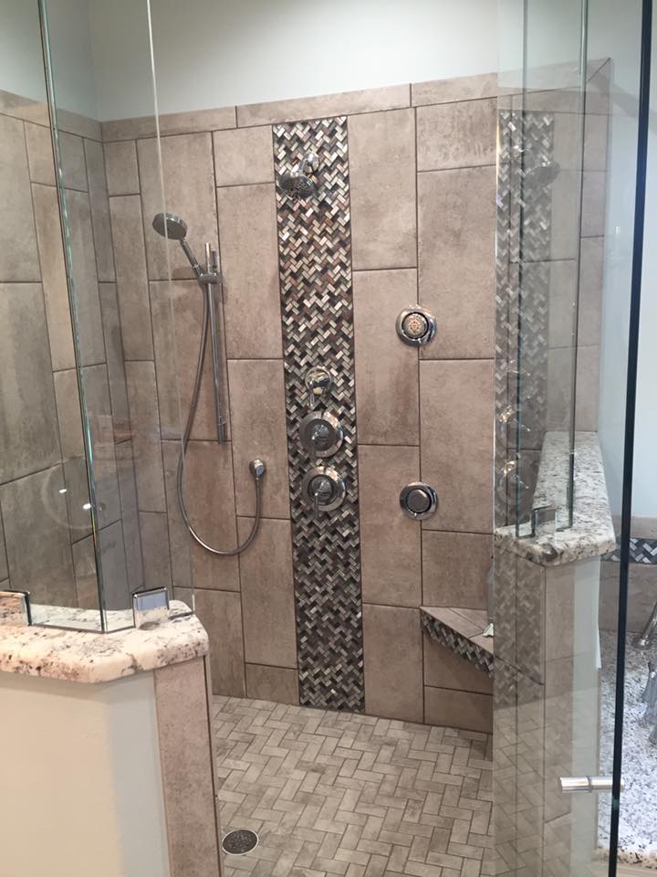 A bathroom with a walk in shower and a glass door.