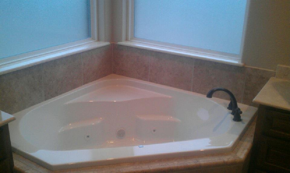 A jacuzzi tub in a bathroom next to a window.