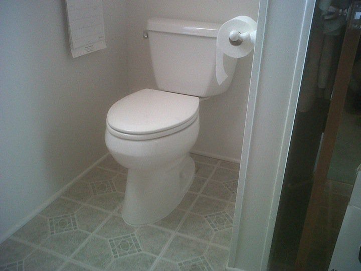 A toilet in a bathroom next to a paper towel