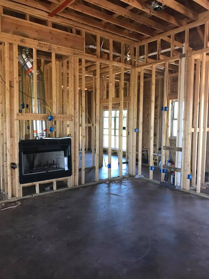 A living room in a house under construction with a fireplace.