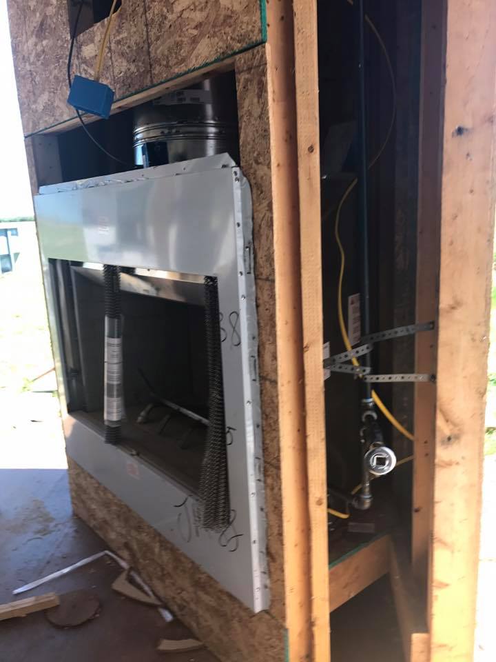 A fireplace is being built into the wall of a house.