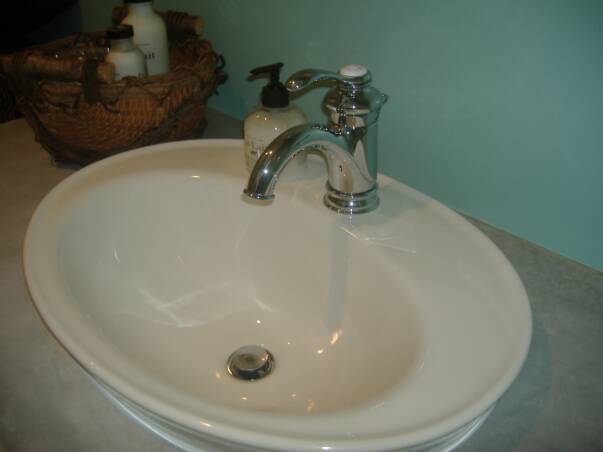 A bathroom sink with water running from the faucet