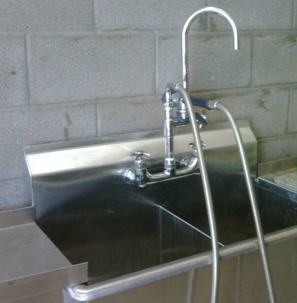 A stainless steel sink with a hose attached to it