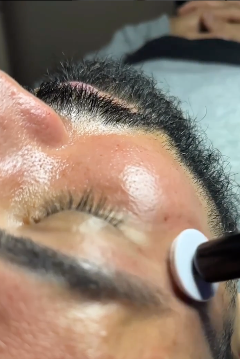 A close up of a person 's face with a brush on it.