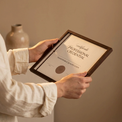 a person holding a framed document that reads Certificate: professional credential