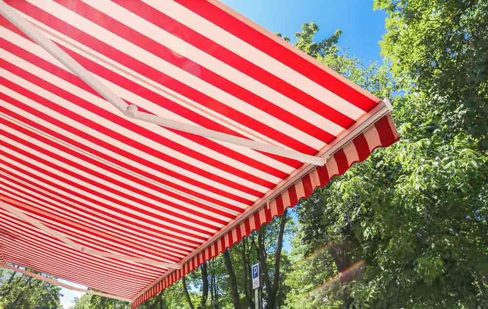 A Red And White Striped Awning Is Hanging Over A Tree — Homemakers Lifestyle In Maroochydore, QLD