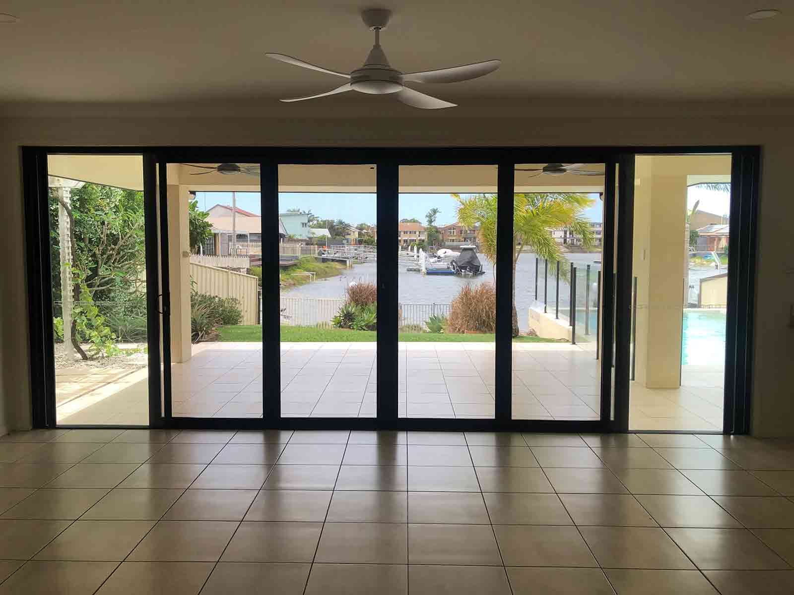 An Empty Room With A Ceiling Fan And Sliding Glass Doors Leading To A Patio — Homemakers Lifestyle In Caloundra, QLD