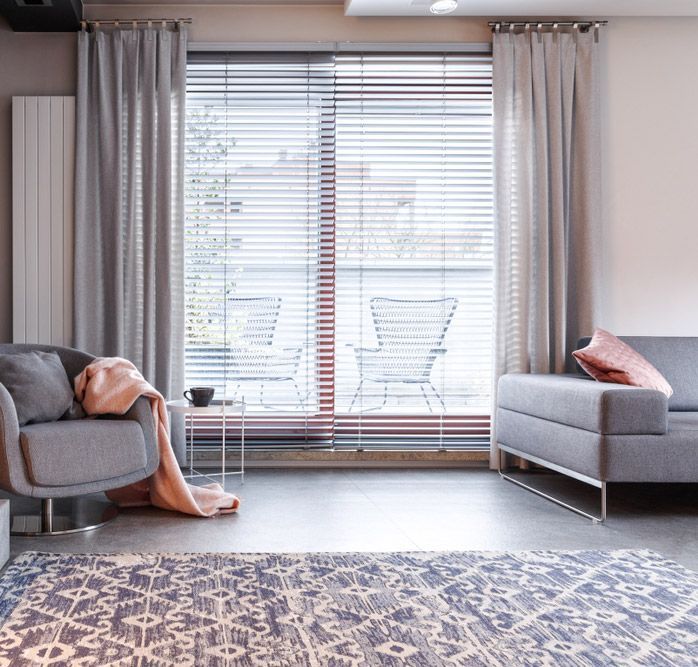 Patterned Carpet and grey Armchair and pink Blanket with Window blinds — Homemakers Lifestyle In Maroochydore, QLD