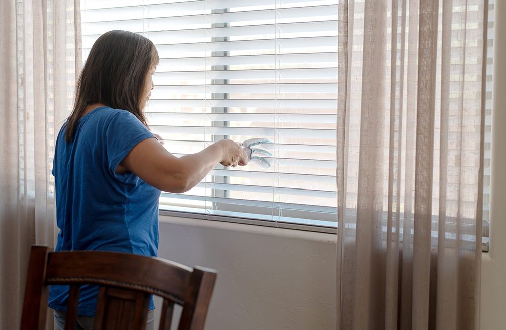 Woman Dusting and cleaning blinds— Homemakers Lifestyle Maroochydore In Maroochydore QLD