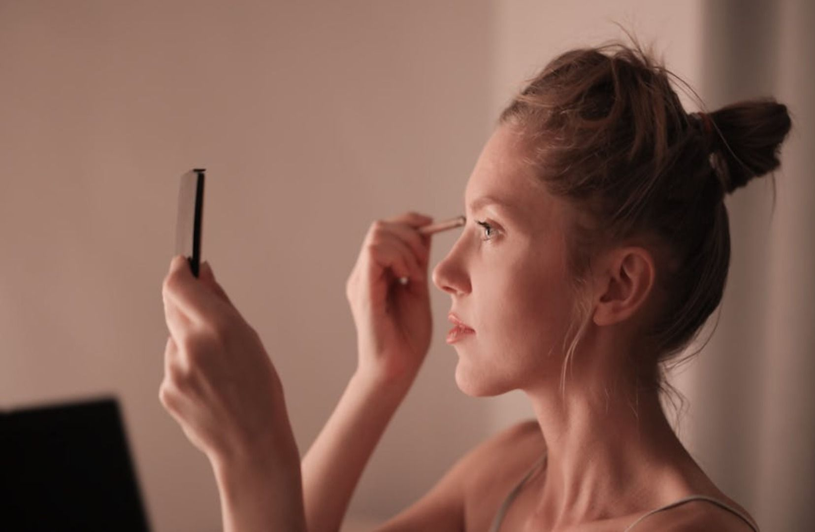 Retrato en primer plano de una persona con maquillaje natural en tonos suaves, expresión neutra y un sutil estilo nupcial.