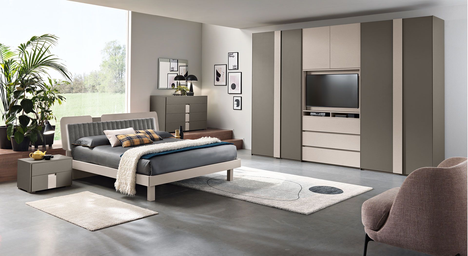 Una camera da letto con un letto, una cassettiera, un comodino e una televisione.