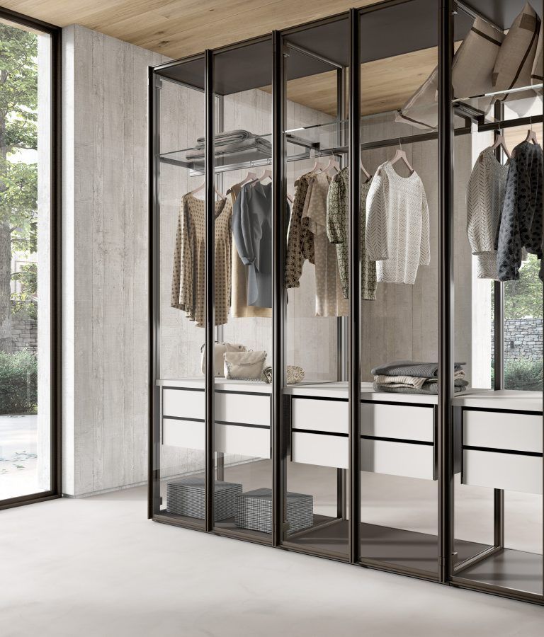 Una cabina armadio piena di vestiti e una grande finestra.