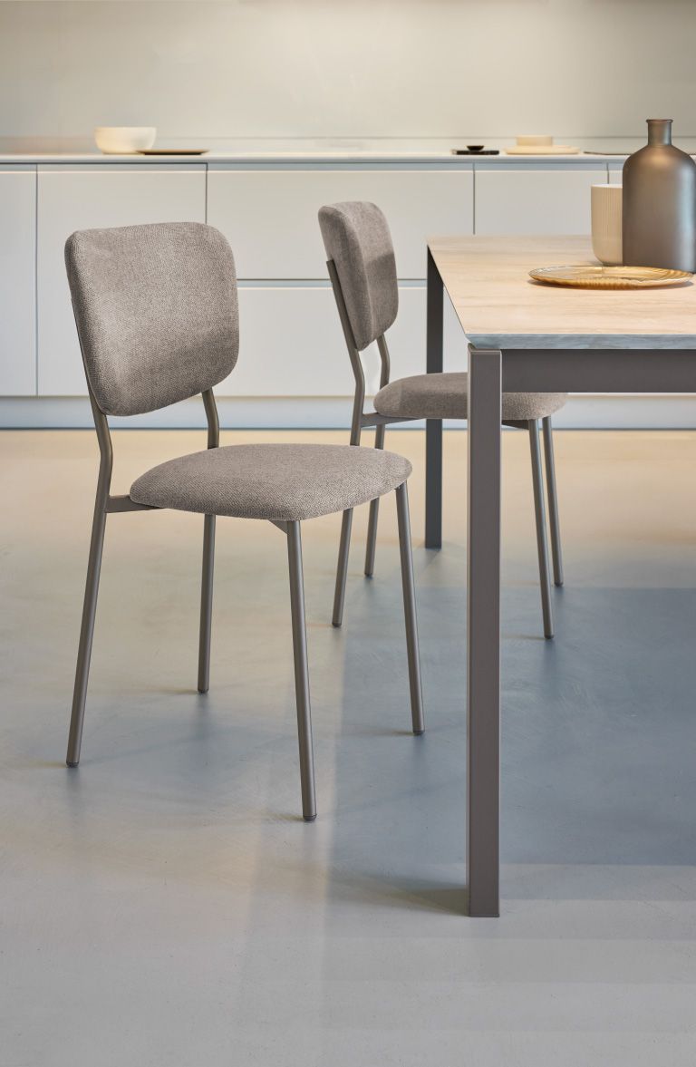 Due sedie sono appoggiate accanto a un tavolo in cucina.