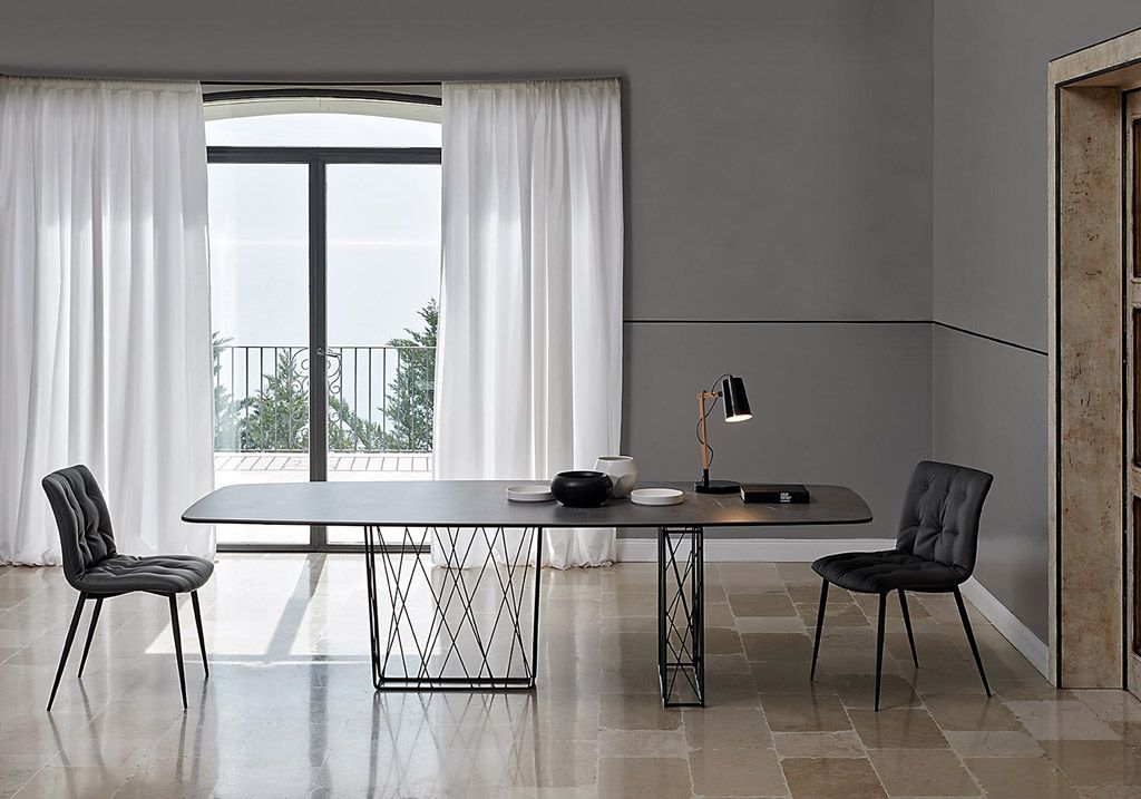 Una stanza con un tavolo e delle sedie davanti a una finestra
