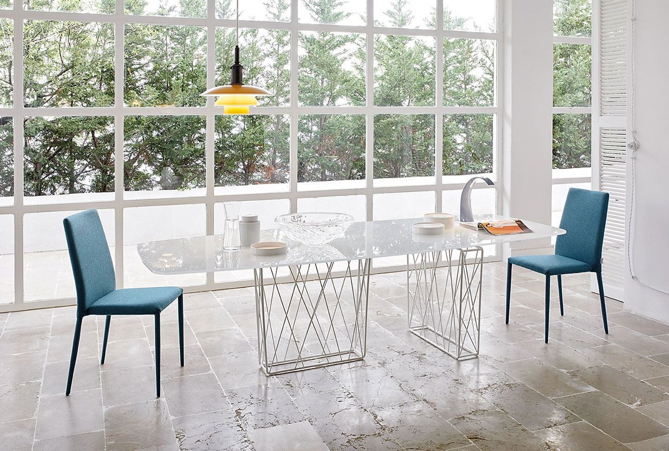 Una sala da pranzo con tavolo e sedie davanti a una grande finestra.