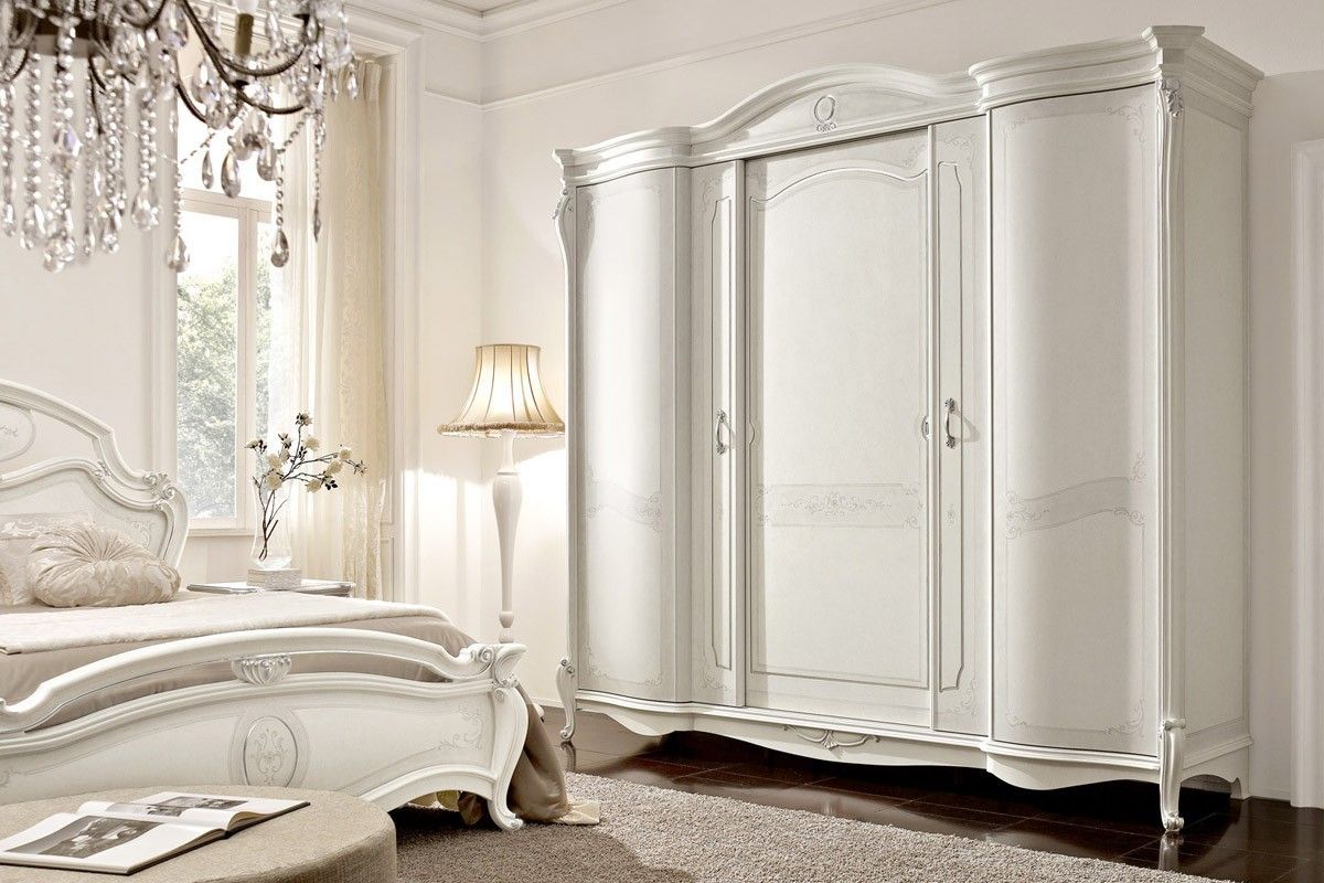 Una camera da letto con letto, armadio e lampadario.