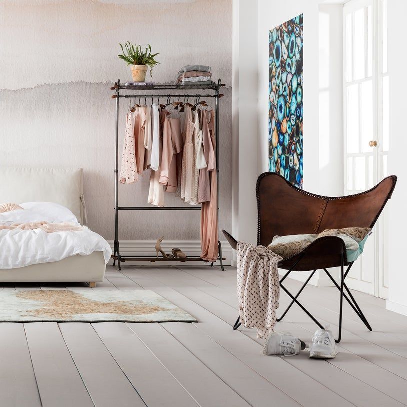 Una camera da letto con una sedia e un attaccapanni