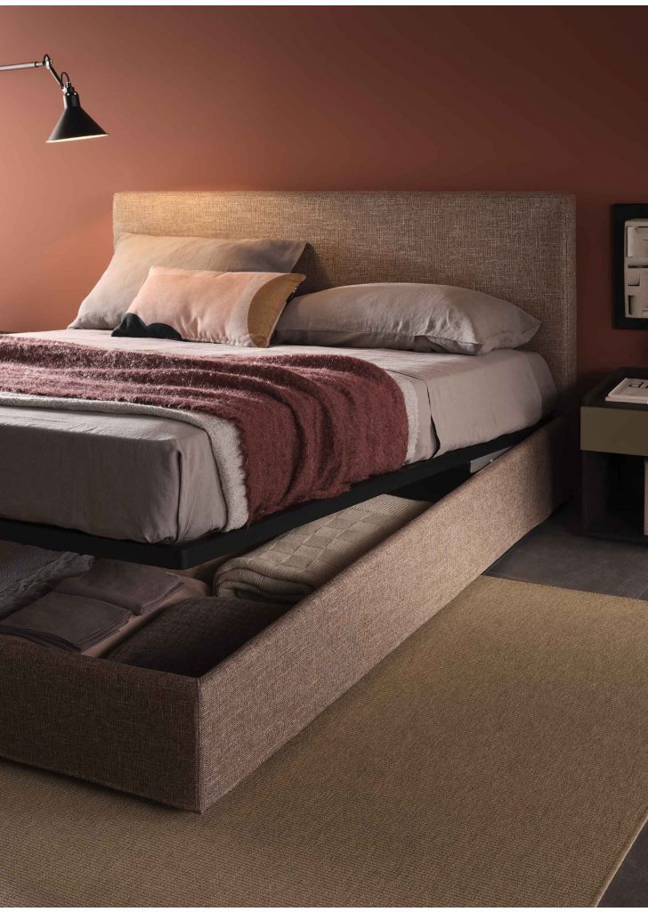 Una camera da letto con un letto e una lampada sul muro