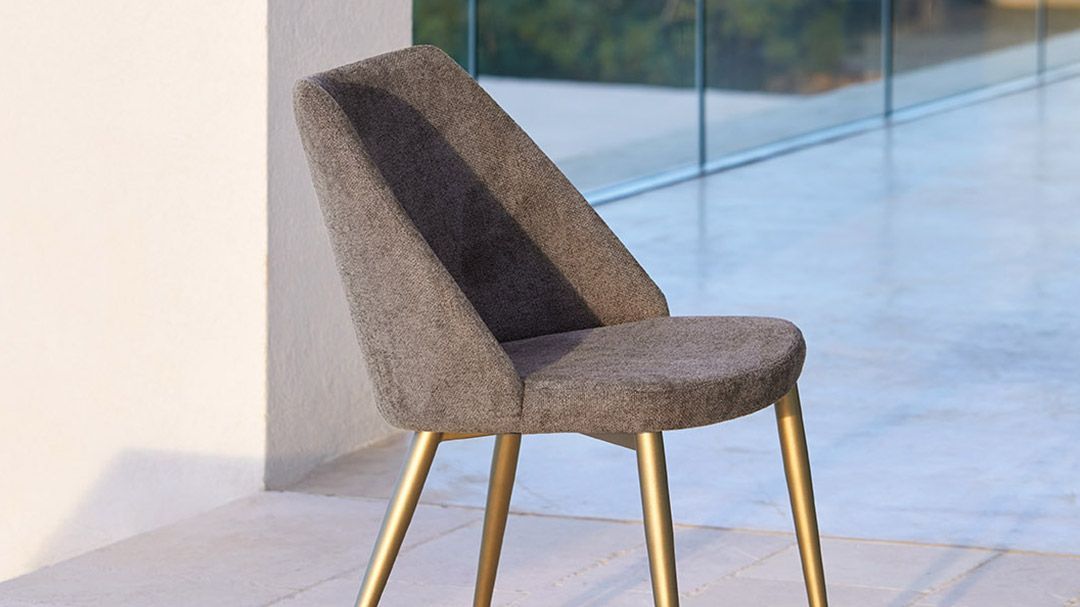 Una sedia è appoggiata su un pavimento piastrellato davanti a una finestra.