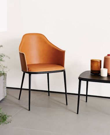 Una sedia è appoggiata accanto a un tavolo in una stanza.