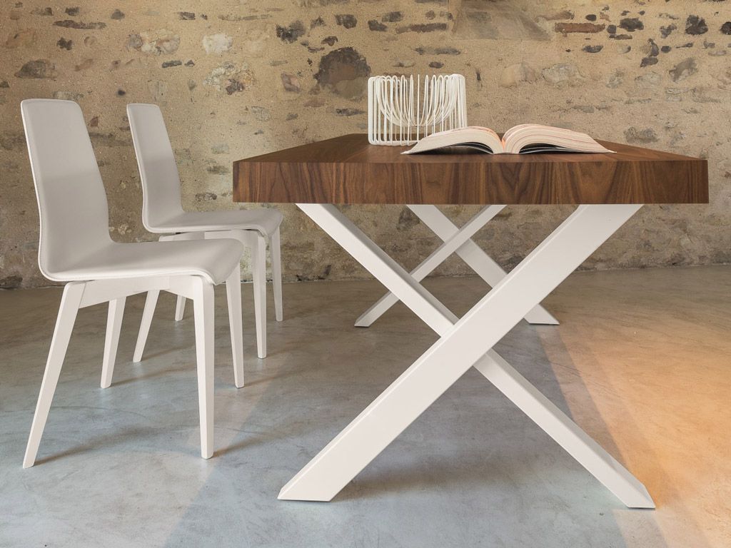 Un tavolo di legno con sedie bianche e un libro sopra