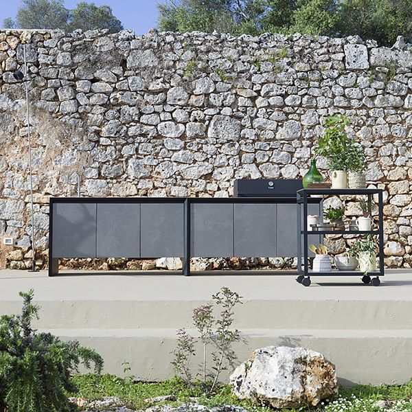 Un muro di pietra dietro una cucina con una griglia sopra