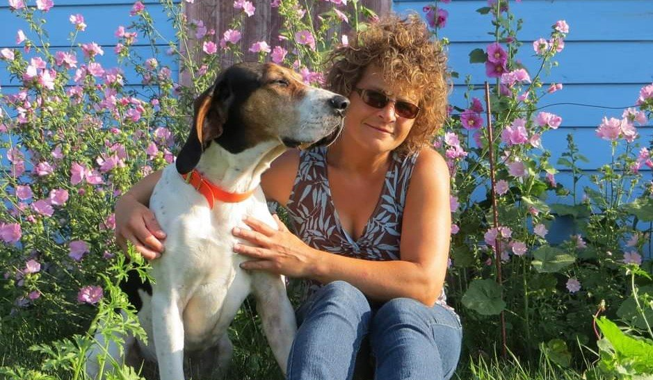 Karen Seginak and dog Hank with Hollyhock flowers