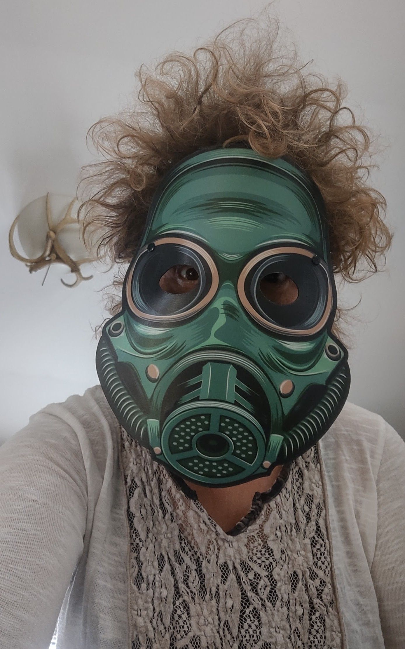 a woman is wearing a green gas mask and taking a selfie .