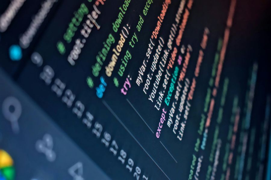 Primer plano de código colorido en una pantalla de ordenador oscura, visto desde un ángulo