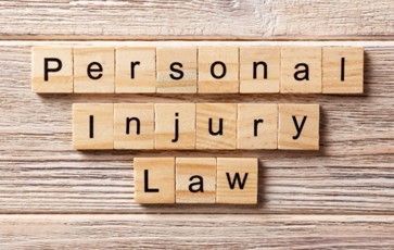 The Word Personal Injury Law Is Written in Wooden Blocks on A Wooden Table.