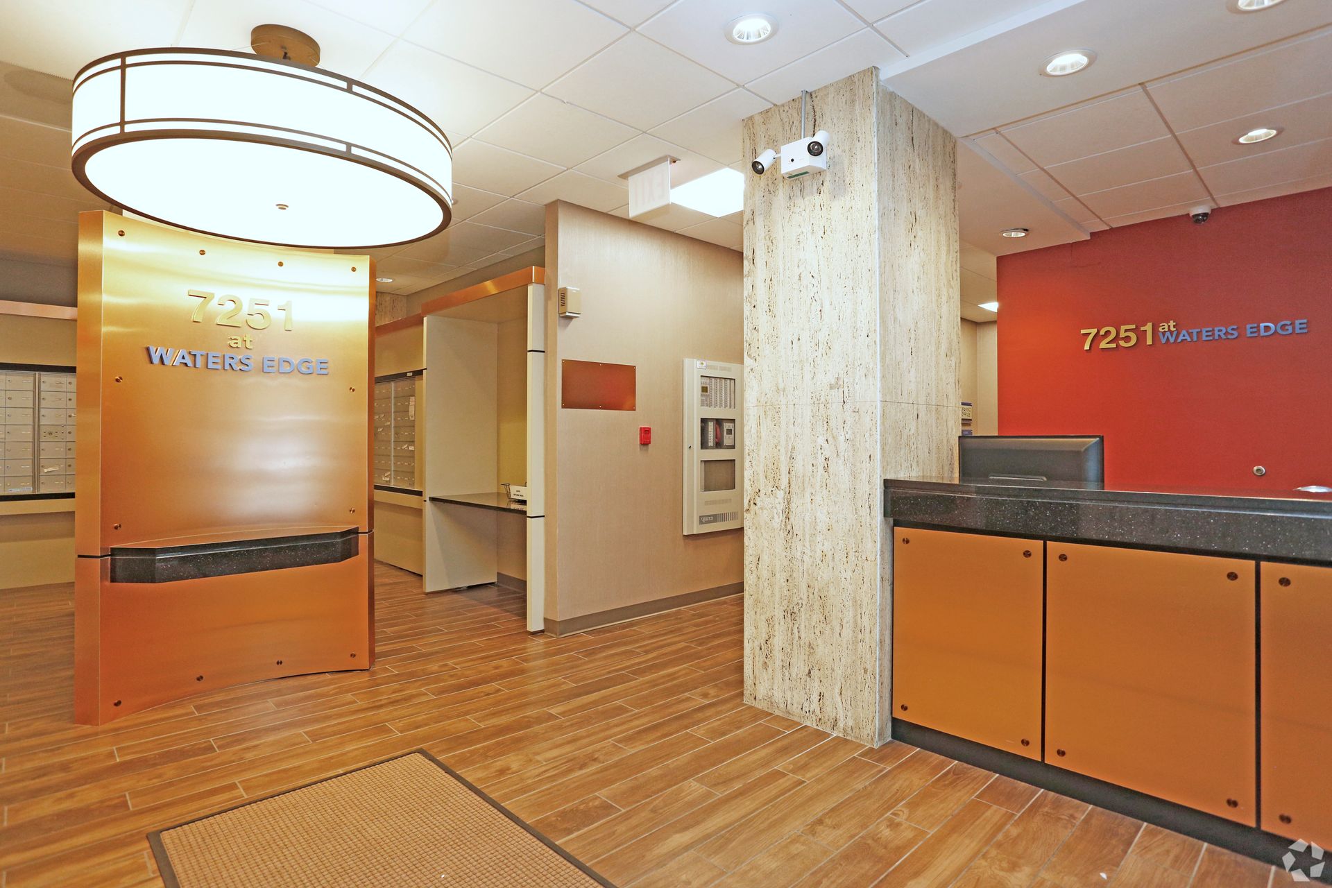 Office lobby with a wooden floor, reception desk, and signage for 