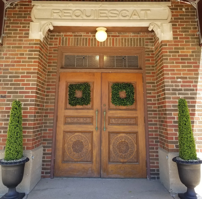 A brick building with a sign above the door that says requiescat