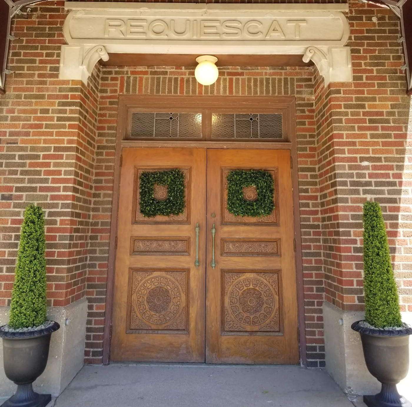 A brick building with a sign above the door that says requiescat