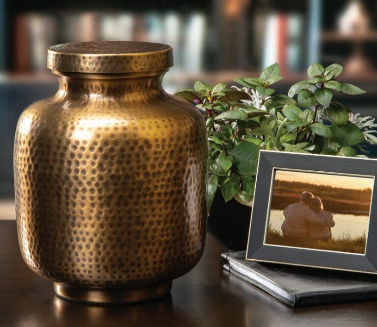 Cremation urn on table next to framed photo