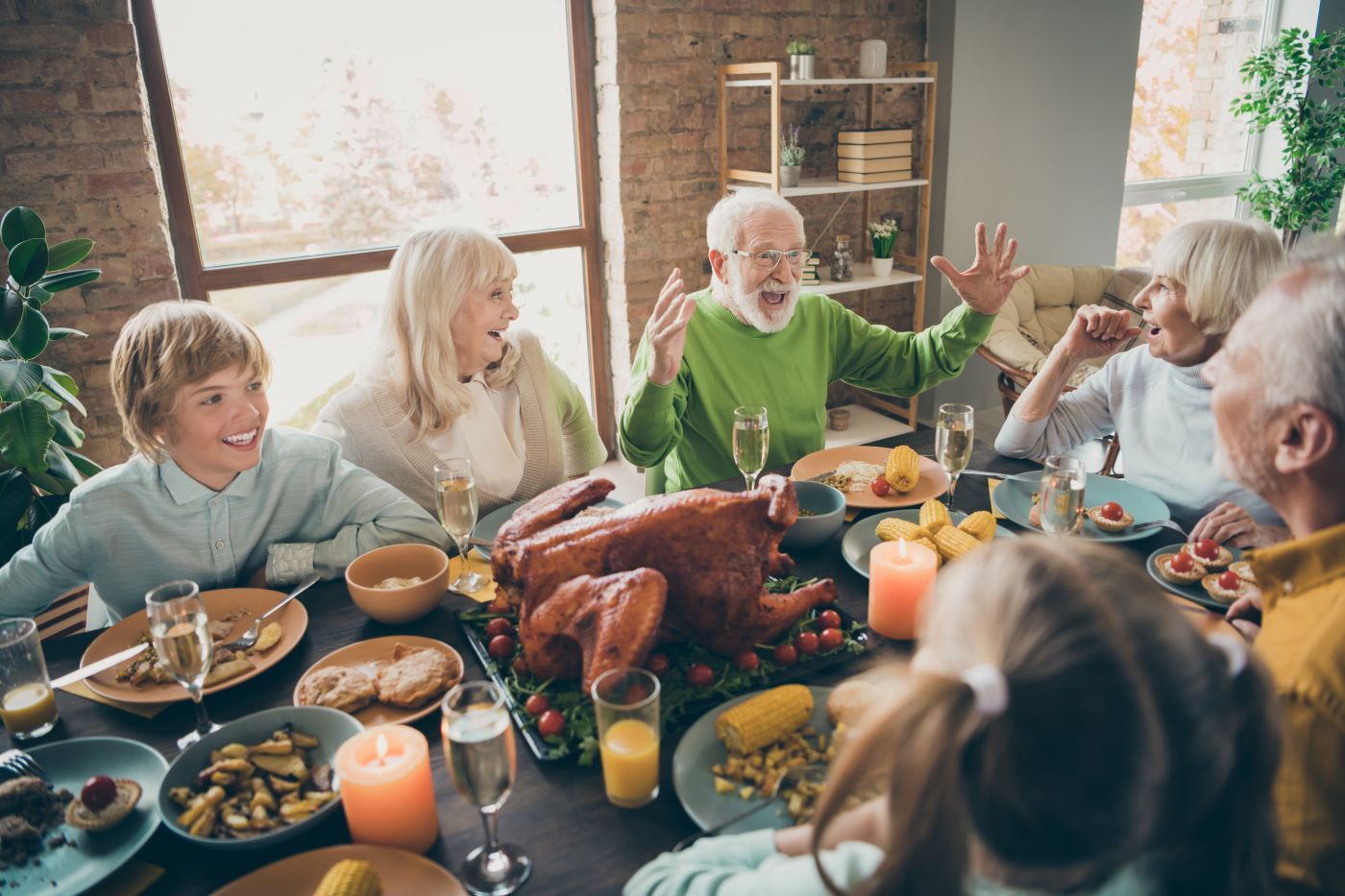 A group of people are sitting around a table eating a turkey.