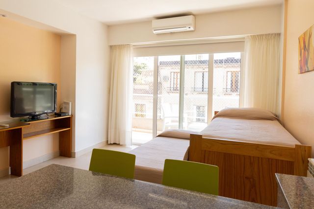 Una sala de estar con una mesa y sillas y una cama.