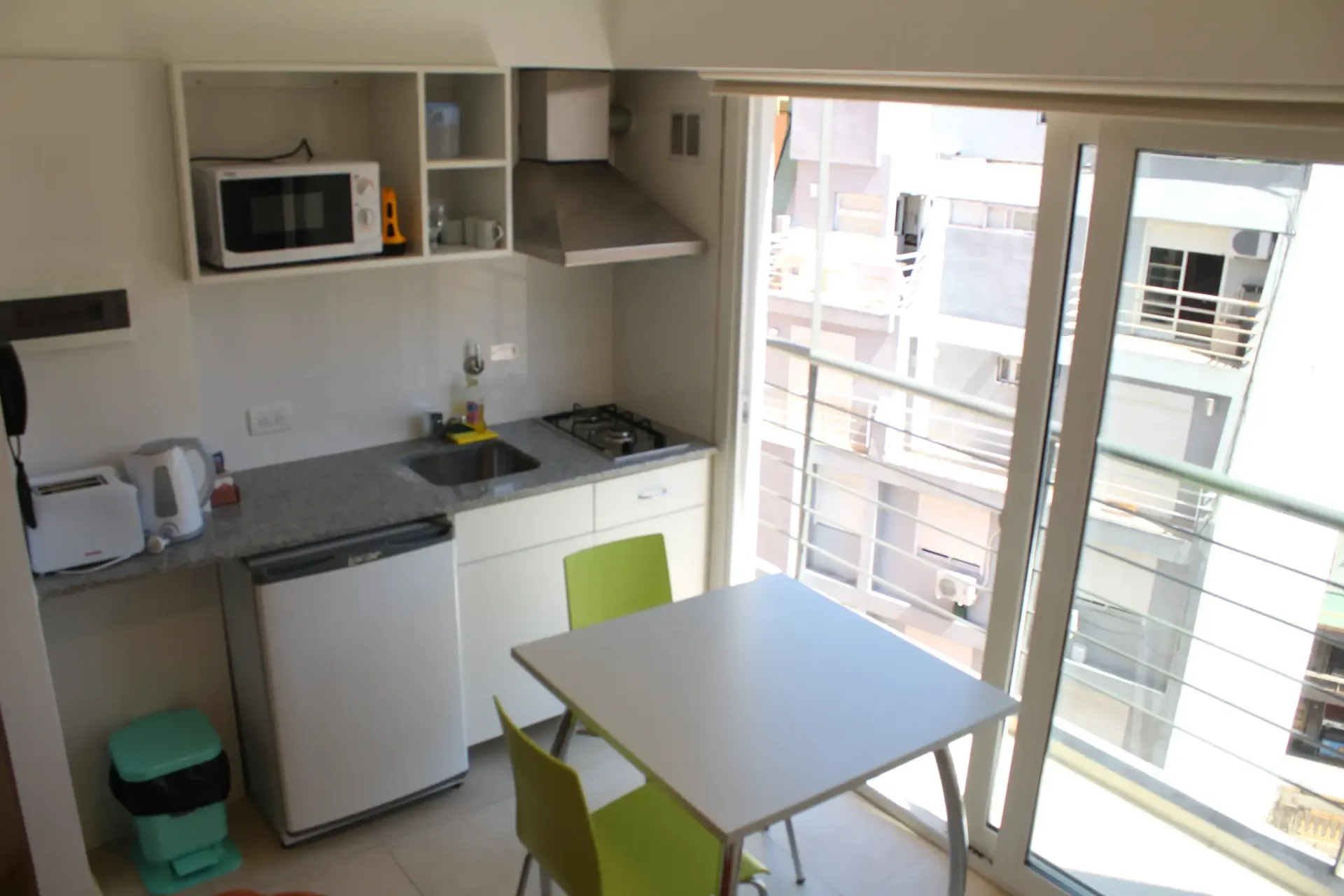 Una cocina con mesa y sillas y un microondas.
